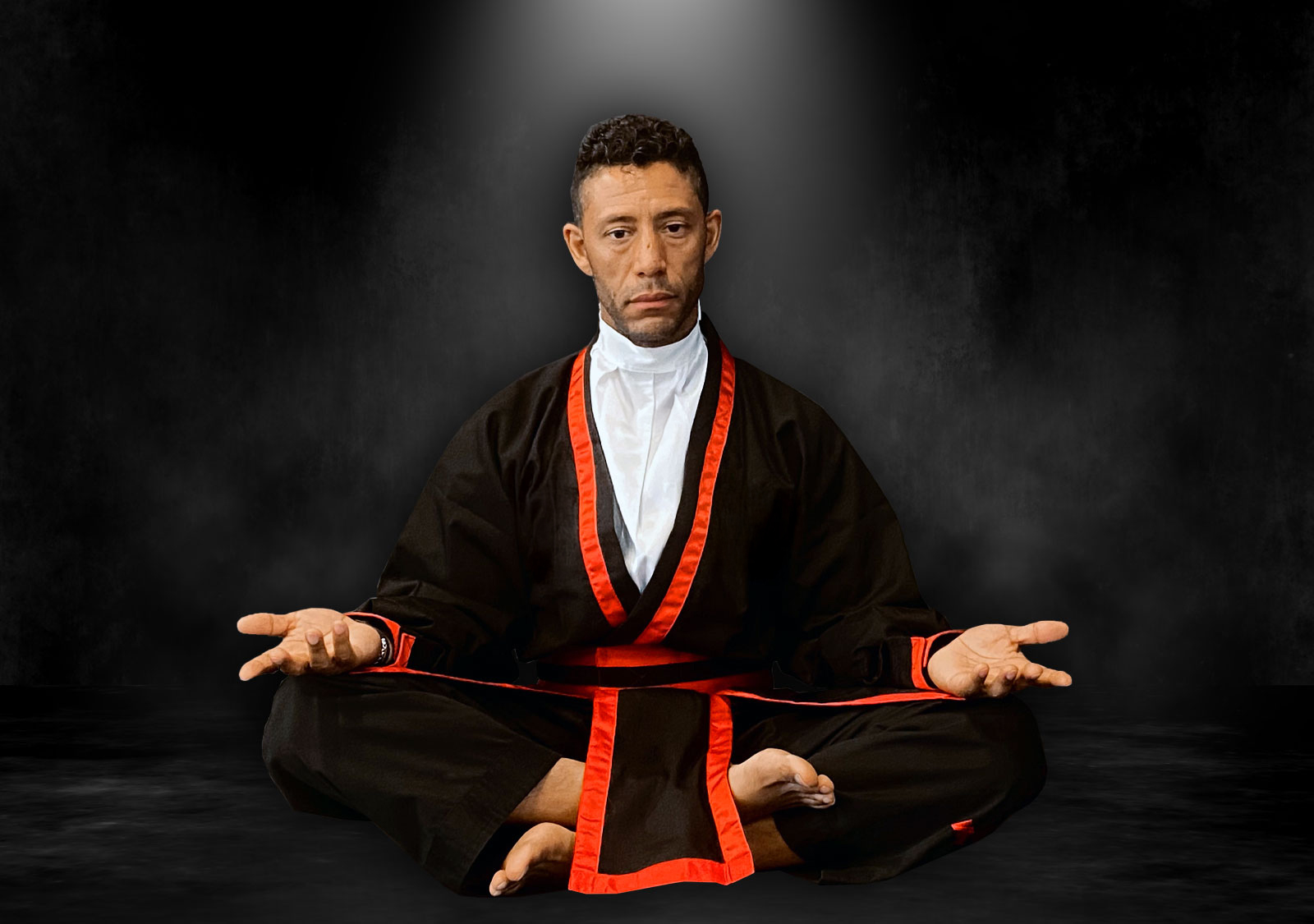 PKJN Nathan, A martial artist wearing a black uniform with red trim sits cross-legged in a meditative pose, hands open and resting on the knees, against a dark, smoky background with a spotlight effect above.